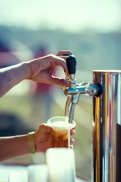 Barman hand at beer tap pouring a draught lager beer — Stock Photo, Image