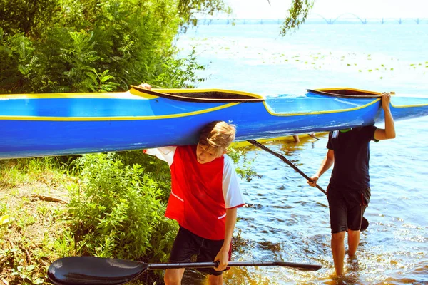 年轻人在美丽的大自然中的一条河上划皮艇. — 图库照片