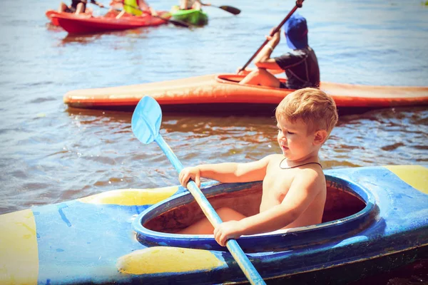 年轻人在美丽的大自然中的一条河上划皮艇. — 图库照片