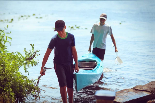 Junge Leute paddeln auf einem Fluss in schöner Natur. — Stockfoto