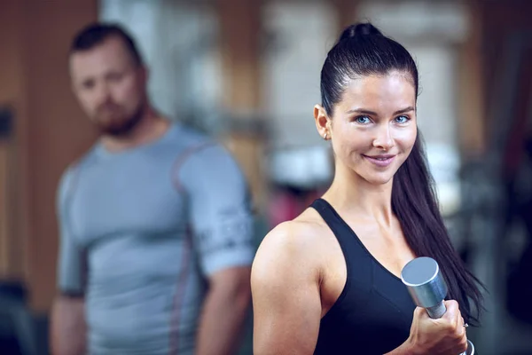 Para robi treningu na maszynie fitness w siłowni. — Zdjęcie stockowe