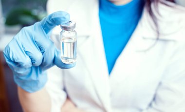 İlaç şişesi elinde, avucunun içinde bir doktor enjeksiyon için.