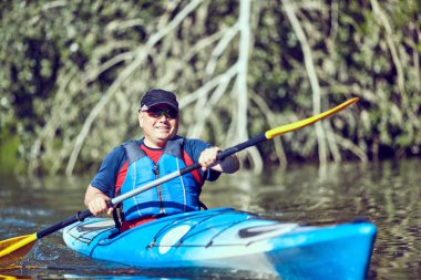  Yaz gününde bir kayık kürek çekmeye adam.