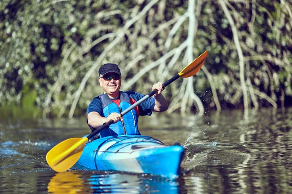 Mann paddelt an Sommertag im Kajak. — Stockfoto