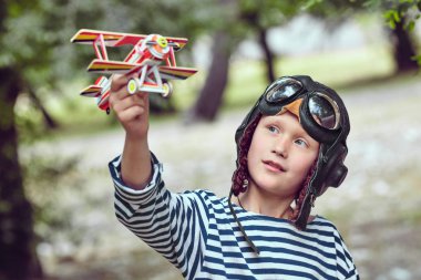 Happy child dreams of becoming a pilot. clipart