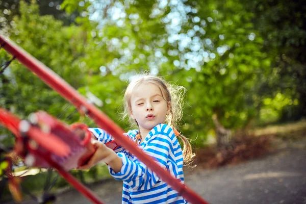 Een meisje in een vest houdt een vliegtuig in haar hand — Stockfoto