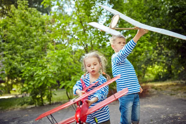 Kinderen in een vest in de hand houden van een vliegtuig — Stockfoto