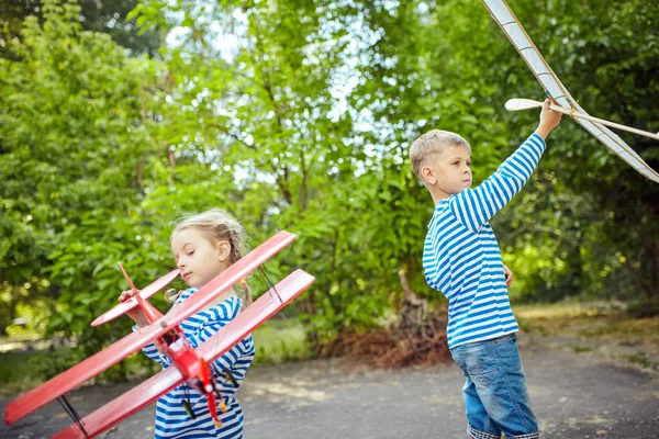 Children in a vest holding a plane in hand — Stock Photo, Image