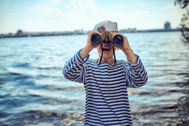 Gemici çizgili yelek dürbün ile içinde bir oğlan