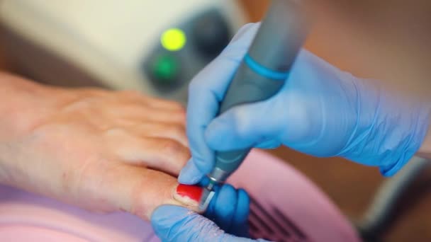 Menina em luvas lida com unhas com um cortador de moagem para manicure — Vídeo de Stock