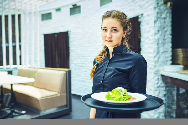 Kelnerzy, niosąc talerze z jedzeniem w restauracji. — Zdjęcie stockowe
