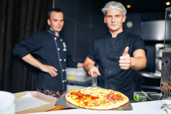 The cook keeps a big pizza — Stock Photo, Image