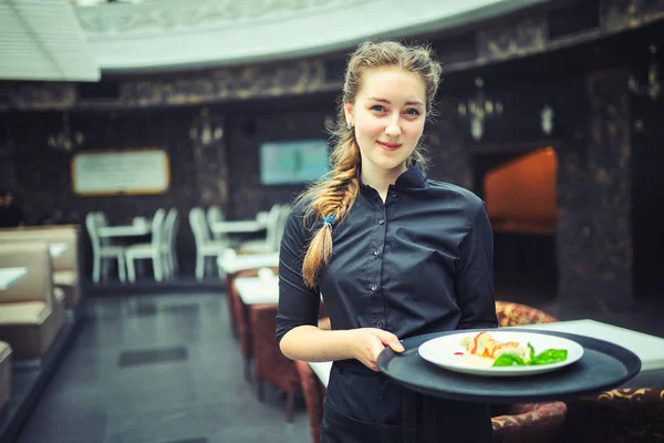 Garçons carregando pratos com comida, em um restaurante . — Fotografia de Stock
