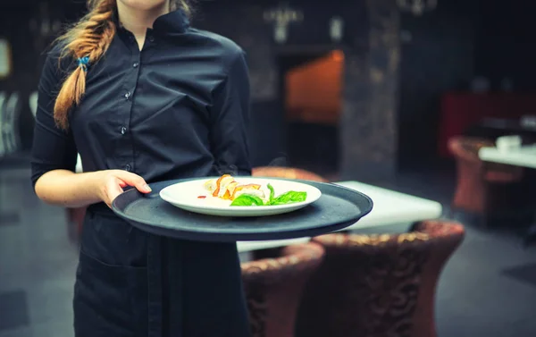 Camareros llevando platos con comida, en un restaurante . — Foto de Stock