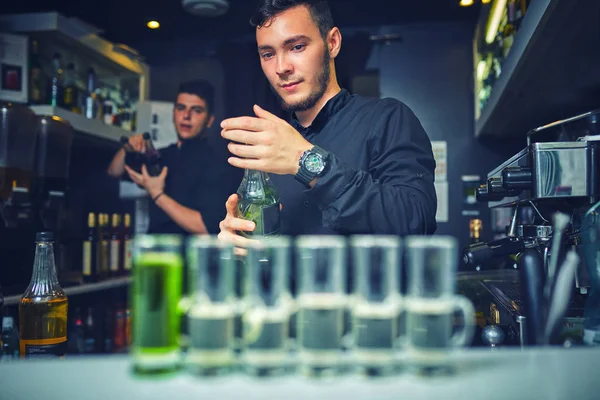 Barman vertiendo el espíritu duro en los vasos — Foto de Stock