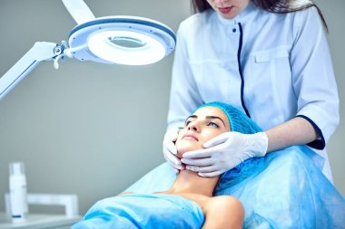 Güzellik uzmanı hastanın yüz için bakıyor