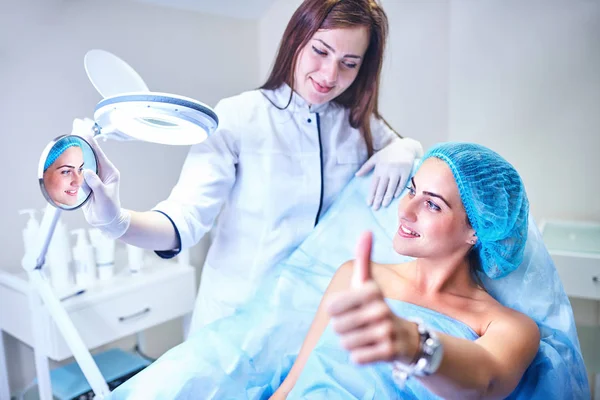 Kosmetolog är vårdande för patientens ansikte — Stockfoto