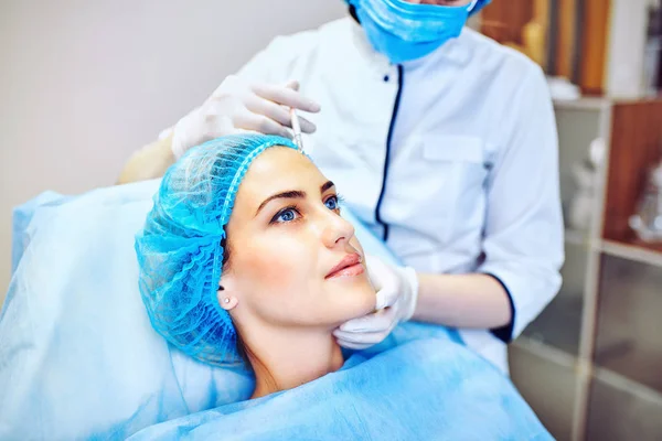 Mulher com face marcada a receber injeção de botox — Fotografia de Stock