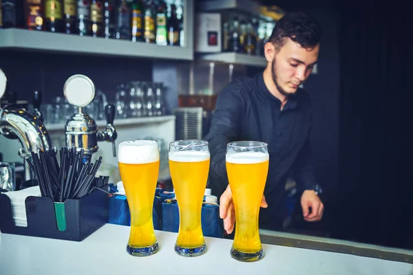 Cantinero sirviendo a los clientes en el bar ocupado — Foto de Stock