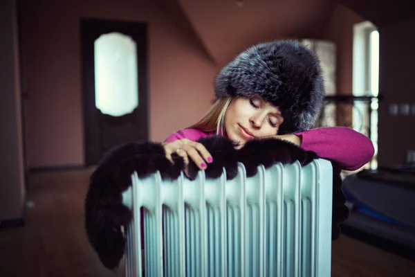 Long-haired woman near electric heater at home — Stock Photo, Image