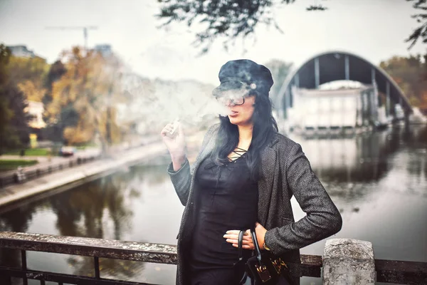 Kvinna med e-cigarett på rost bakgrund — Stockfoto