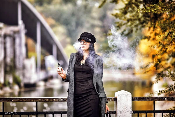 Frau mit E-Zigarette auf Rost-Hintergrund — Stockfoto