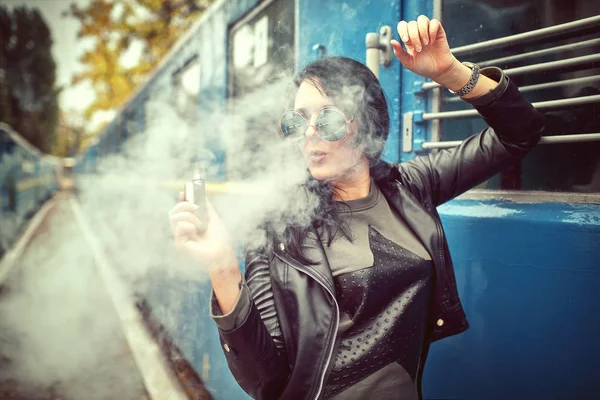Perempuan dengan e-rokok di latar belakang berkarat — Stok Foto