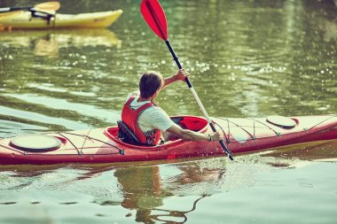  Yaz gününde bir kayık kürek çekmeye adam.