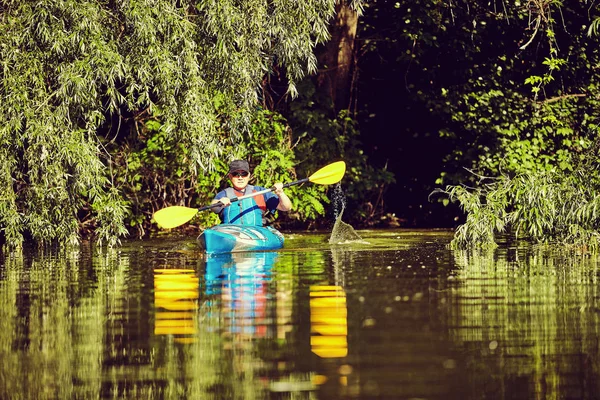 Mann paddelt an Sommertag im Kajak. — Stockfoto