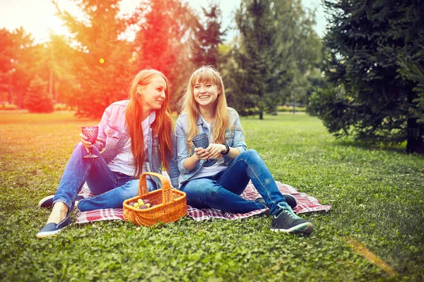 Tytöt lepäävät puistossa nurmikolla. — kuvapankkivalokuva