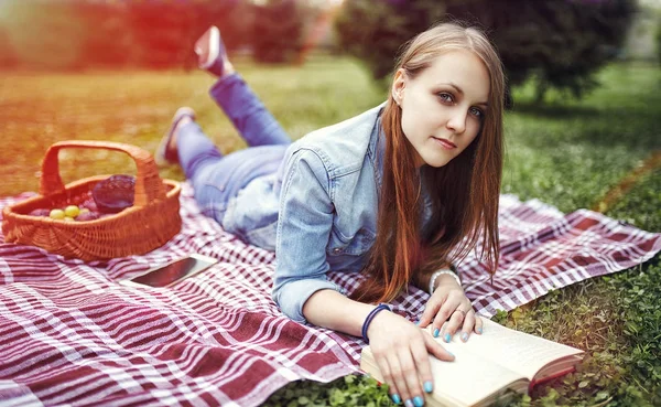 Menina leitura livro no parque no verão pôr do sol ligh — Fotografia de Stock