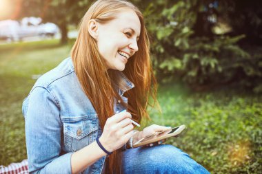 Kız parkta çim üzerinde dinleniyor