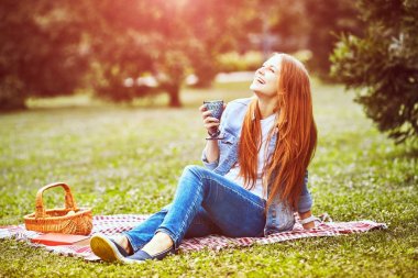 Kız parkta çim üzerinde dinleniyor