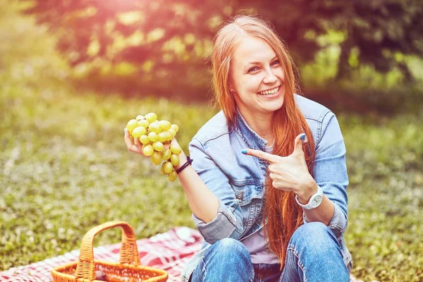 Dívka je odpočívá v parku na trávě — Stock fotografie