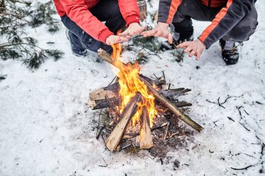 Mutlu çift bir kamp ateşi karlı kış orman üzerinde
