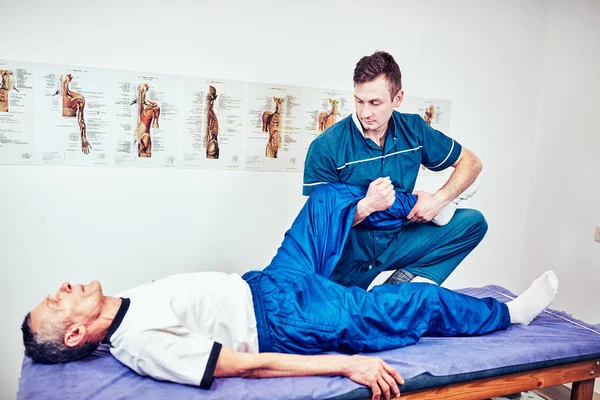 Fisioterapeuta tratando a un paciente en el consultorio de un paciente —  Fotos de Stock