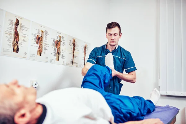 Physiotherapist treating a patient in a patient's office — Stock Photo, Image