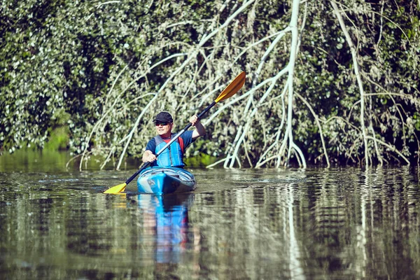 Mann paddelt an Sommertag im Kajak. — Stockfoto