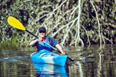  Yaz gününde bir kayık kürek çekmeye adam.