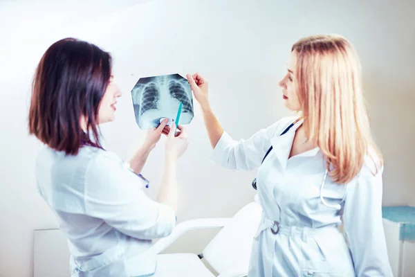 Vrouwelijke arts diagnose van x-ray afbeelding tonen aan patiënt . — Stockfoto