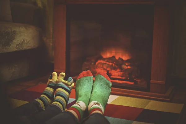 Pies en calcetines de lana cerca de la chimenea en invierno — Foto de Stock