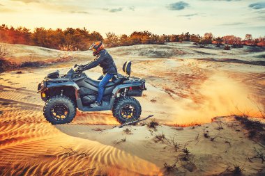 Kum tepeleri içinde Atv sürme Genç kum bir dönüş yapma
