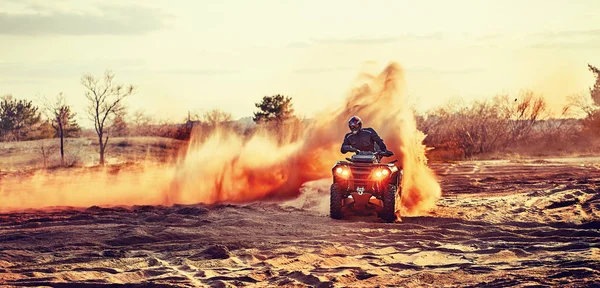 Adolescente cabalgando ATV en dunas de arena haciendo un giro en la arena — Foto de Stock