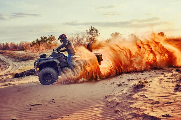 Teen Reiten atv in Sanddünen machen eine Wendung im Sand — Stockfoto