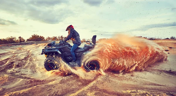 Teen riding ATV in sand dunes making a turn in the sand — Stock Photo, Image