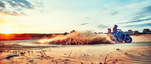 Tonåring ridning ATV i sanddyner gör en sväng i sanden — Stockfoto