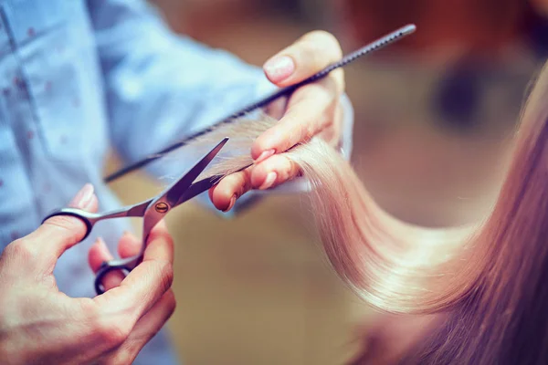 Fryzjer obcina długie włosy w salonie fryzjerskim — Zdjęcie stockowe