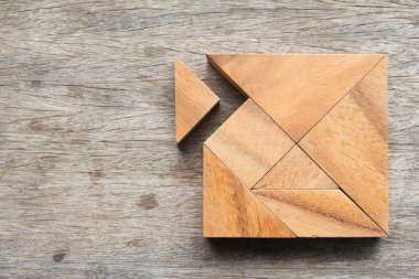 Tangram bulmacanın beklemek için yerine getirmek için ahşap masa üzerinde kare şekli