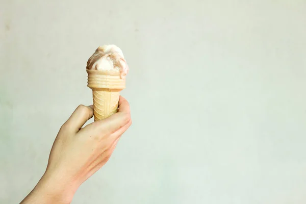 Female hold melt sweet ice cream on concrete background