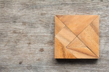 Tangram bulmacanın ahşap masa üzerinde kare şeklinde